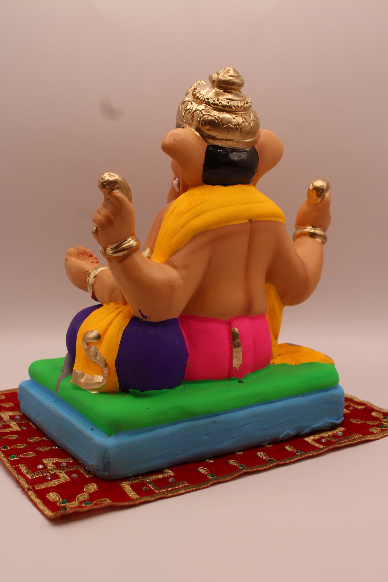 Back view – yellow khes and rani pink dhoti on a purple cushion