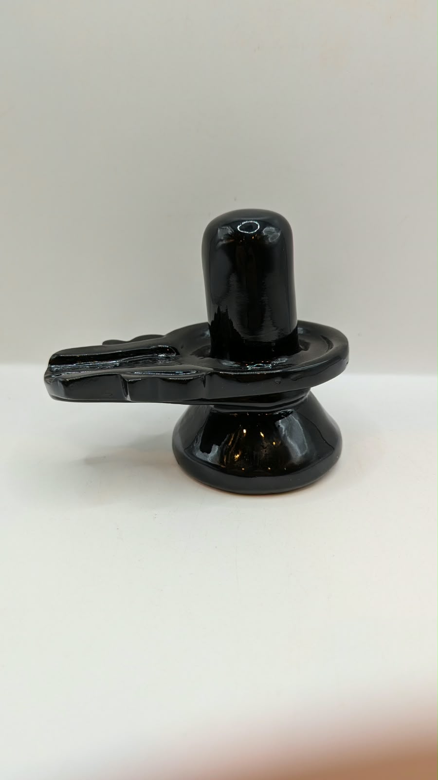 Glossy black Shivling statue, back view