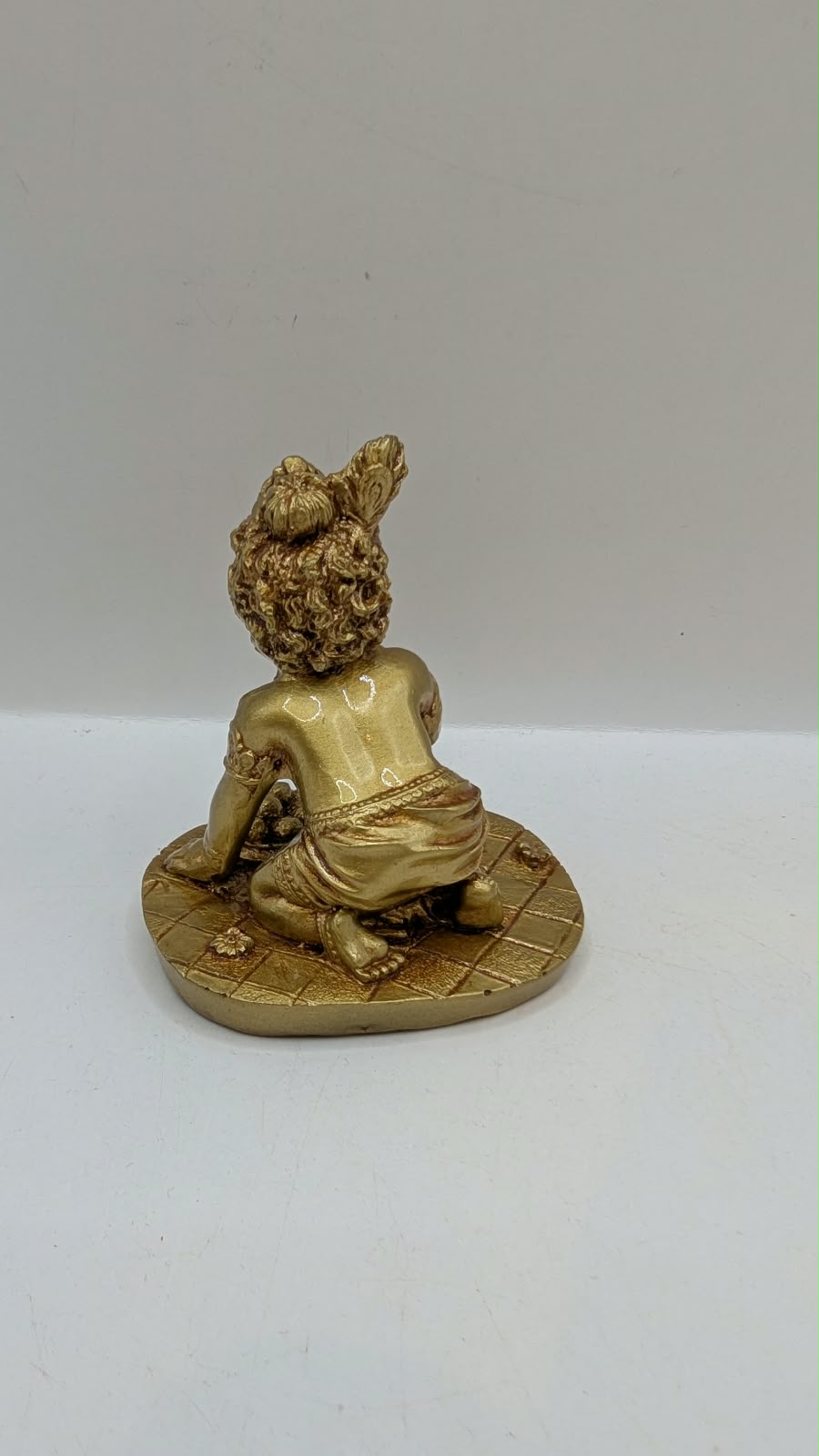 Gold crawling baby Krishna statue, back view