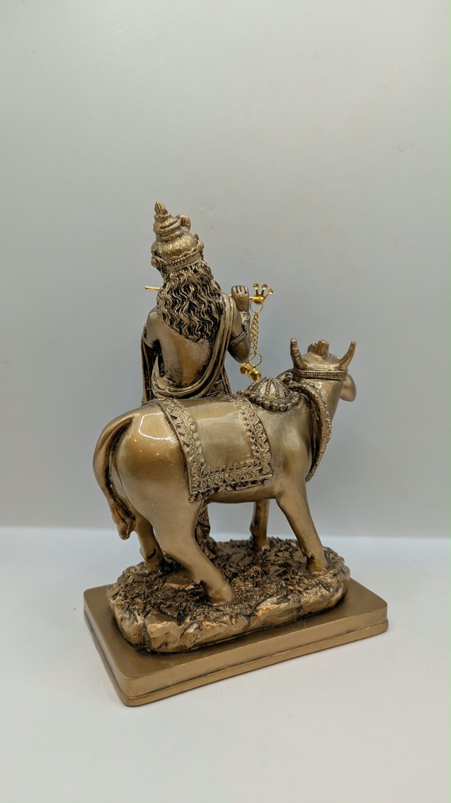 Antique gold Krishna with cow statue, back view