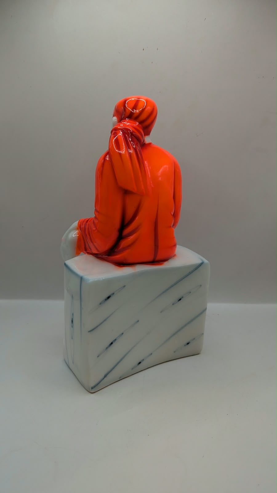 Sai Baba statue on white seat, back view