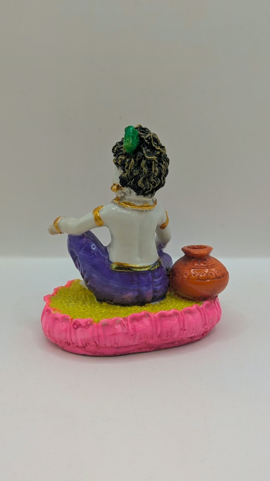 Baby Krishna statue in purple dhoti, back view