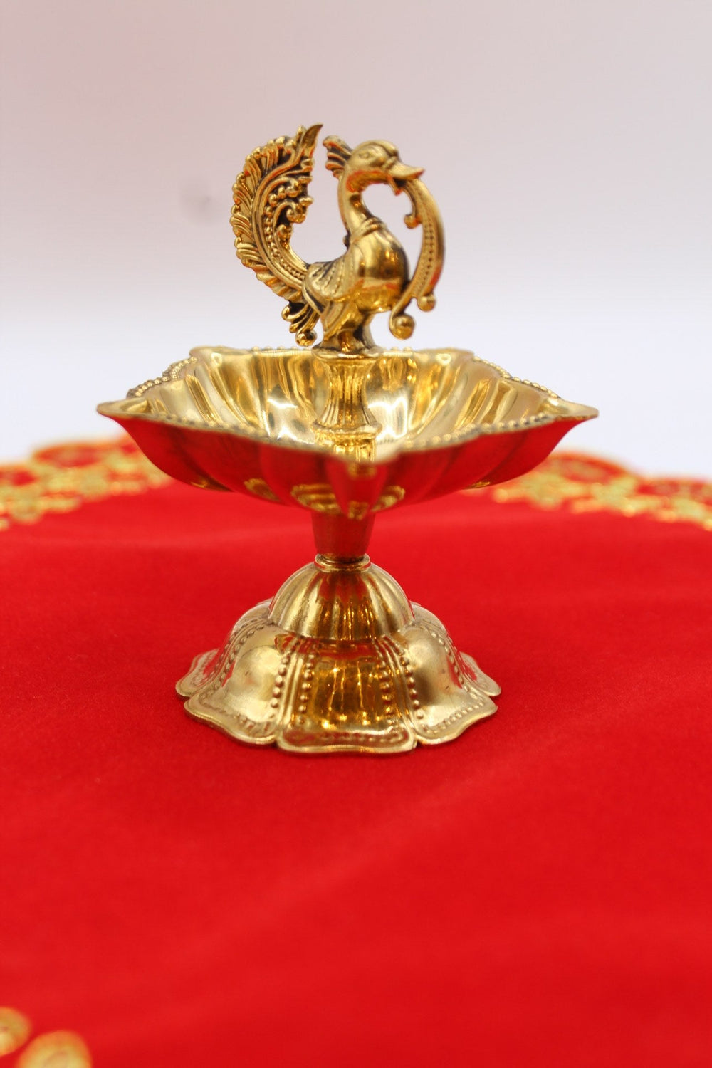 Solid brass peacock diya on a fluted pedestal