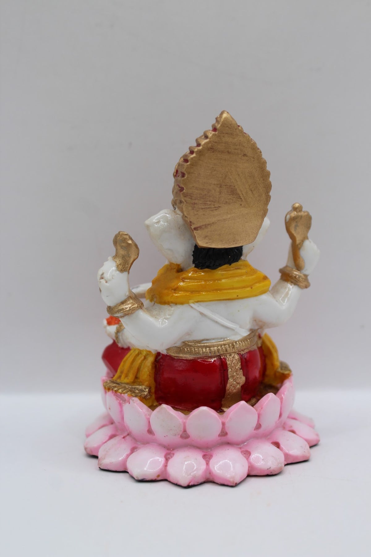 Resin Ganesh murti on pink lotus, red dhoti, back view