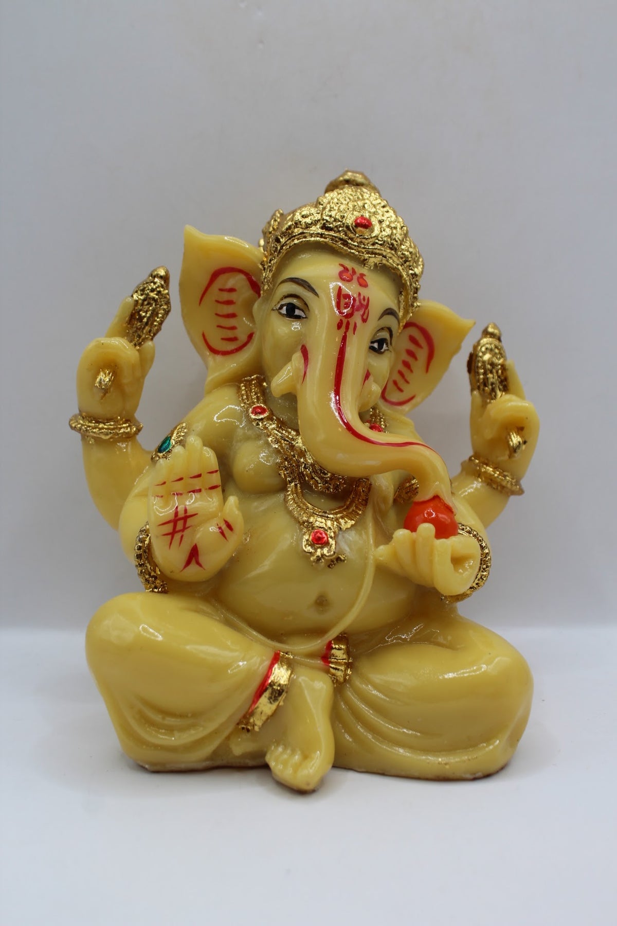 Cream resin Ganesh murti seated, gold crown, front view
