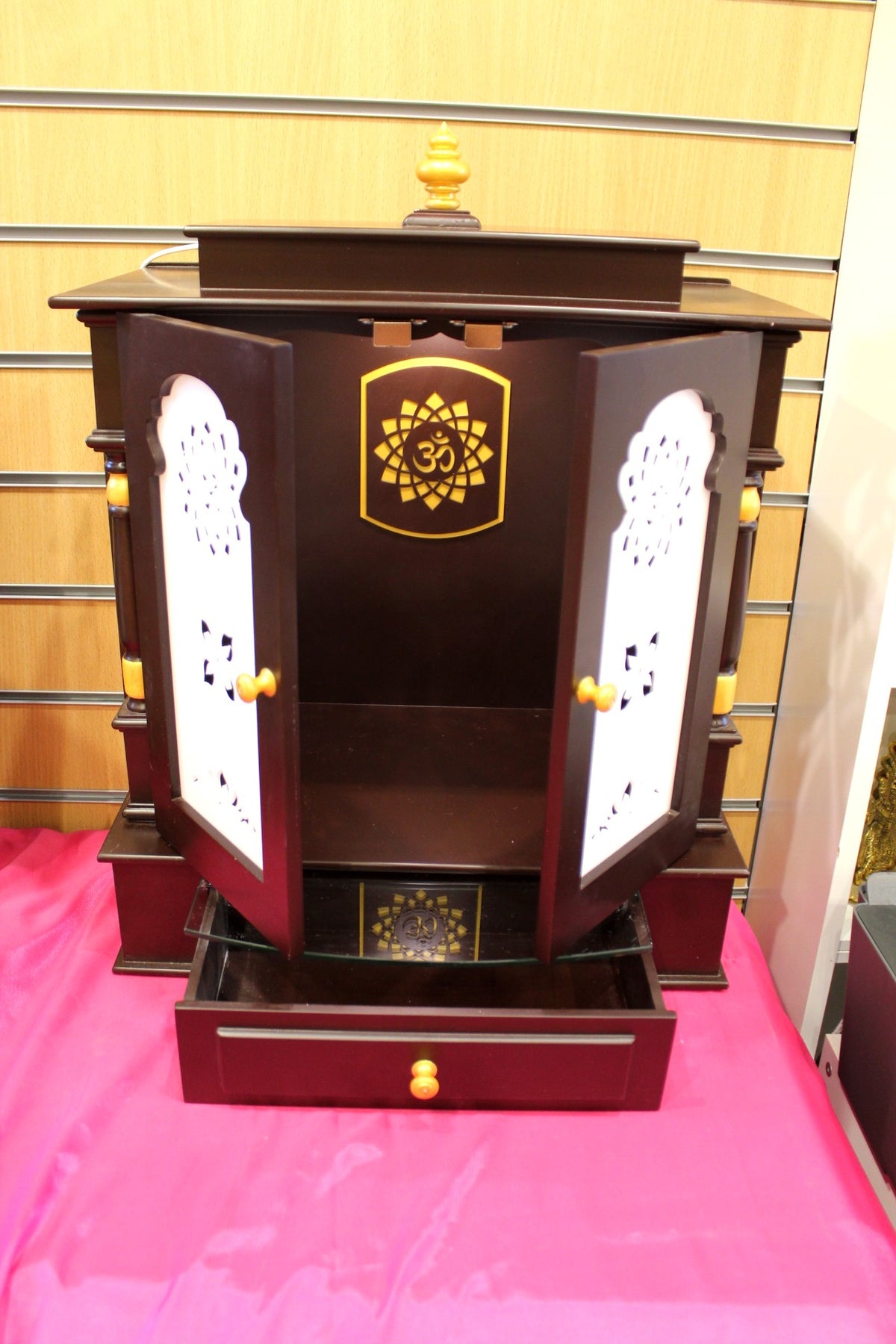 Wooden mandir with doors open and interior light on