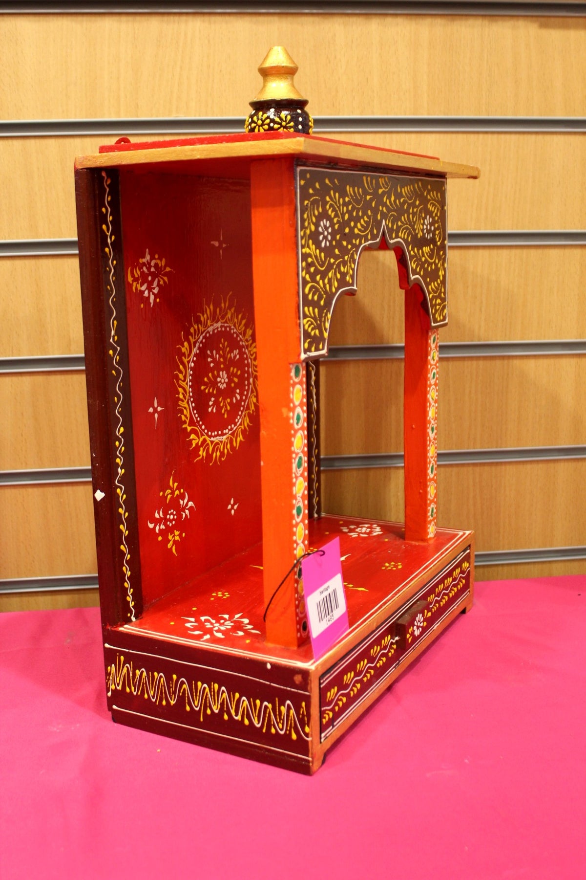 Red painted mandir shown at a side angle