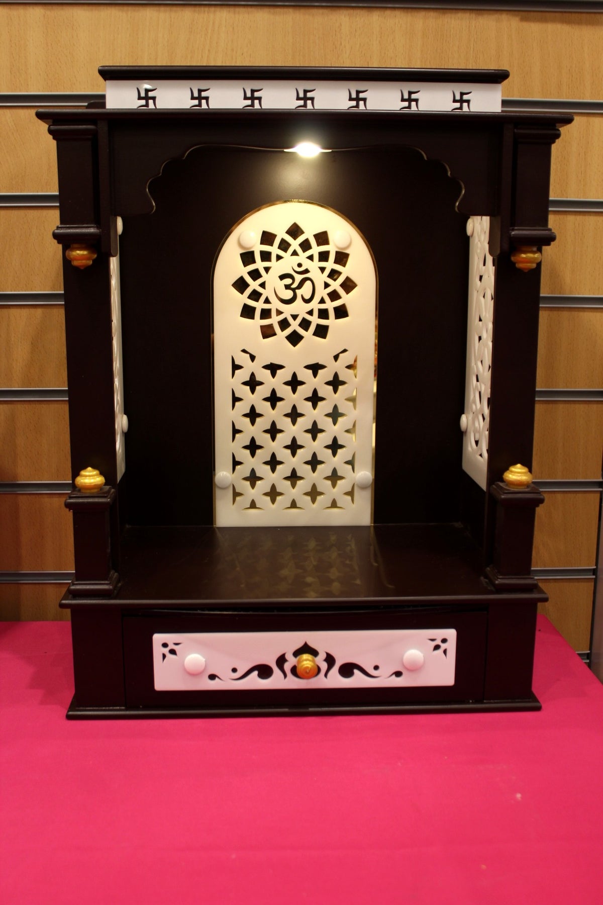 Dark wood open-front mandir with Om jali arch and lights, front view