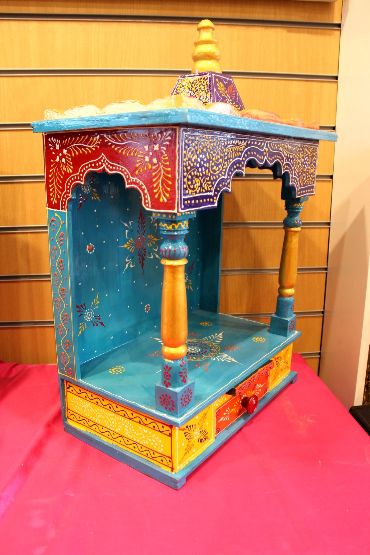 Blue painted home temple shown at a side angle