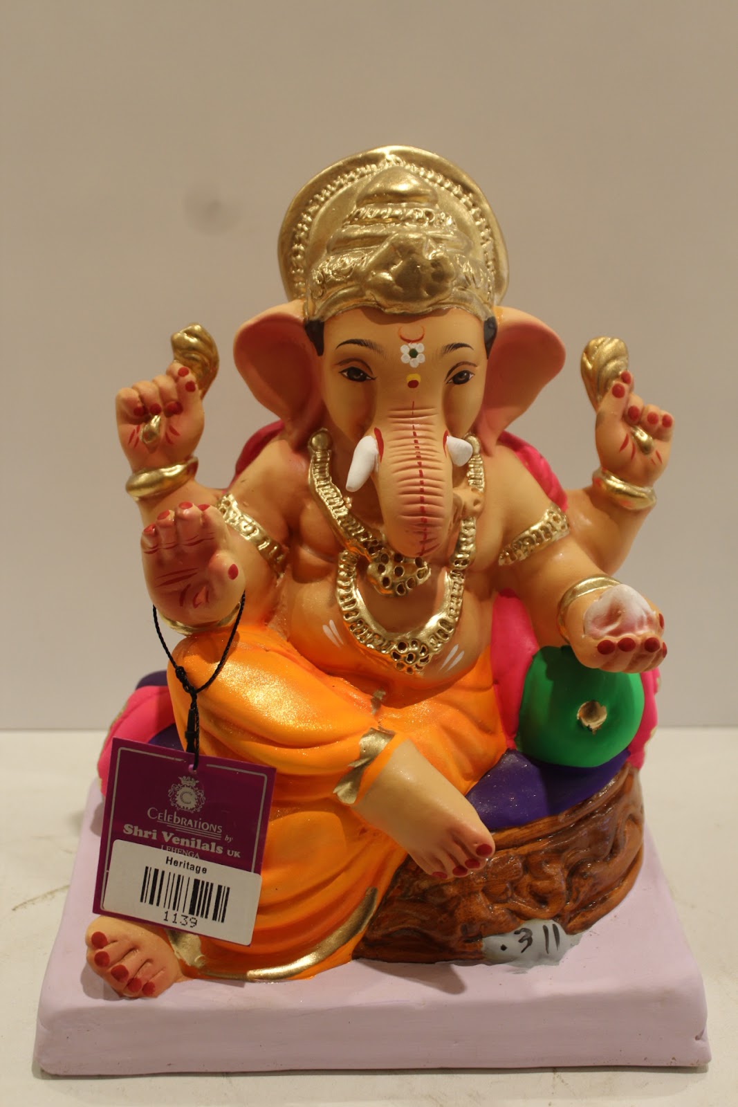 Eco-friendly clay Ganesh idol with pink khes, orange dhoti and basket throne, front view