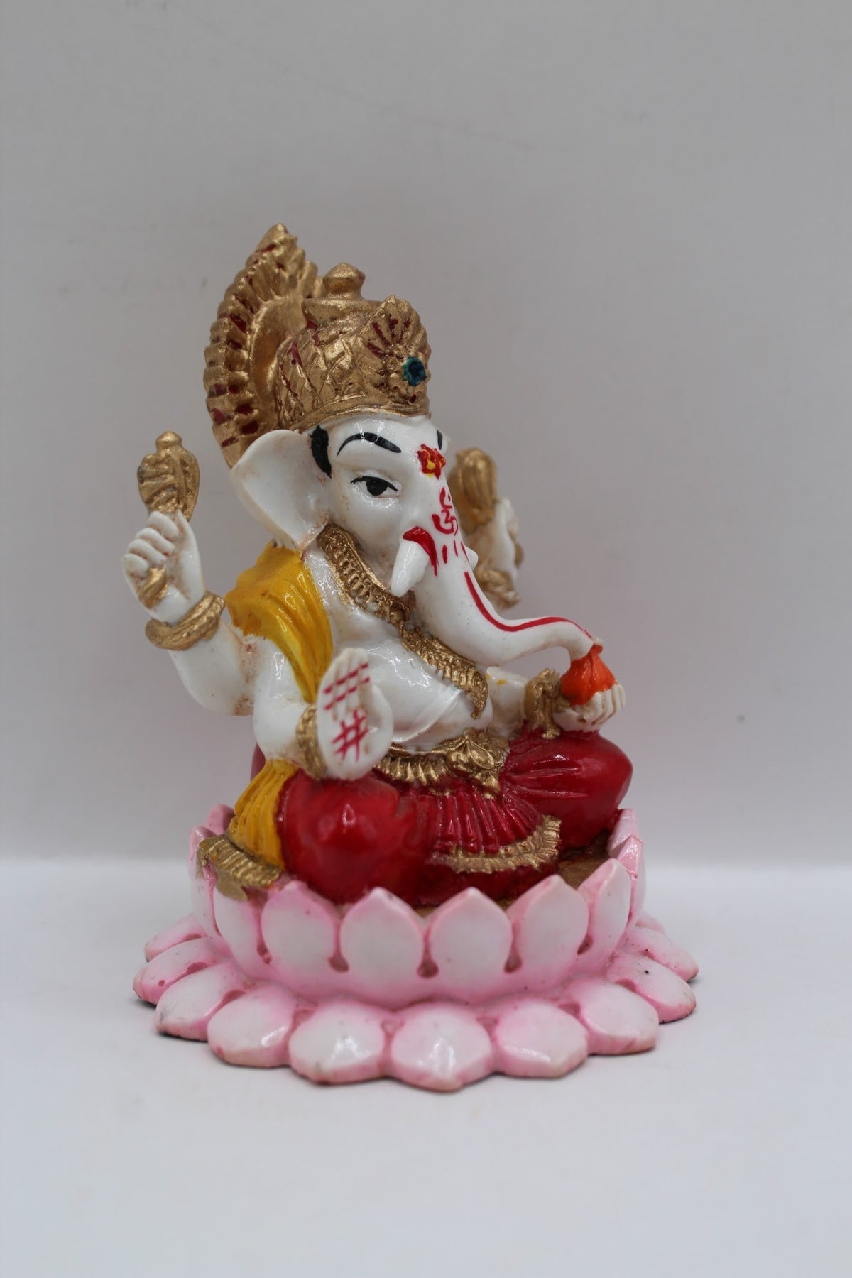 Resin Ganesh murti on pink lotus, red dhoti, left side view