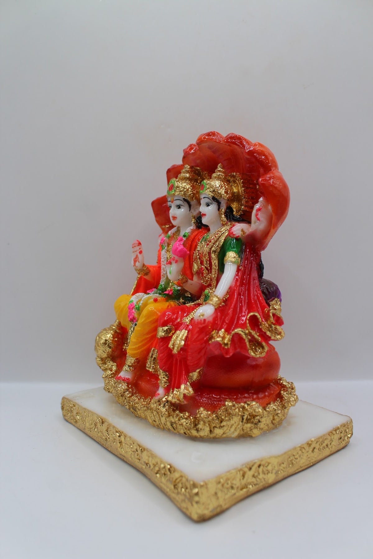Red resin Vishnu Laxmi murti, seated under Sheshnaag, right side view