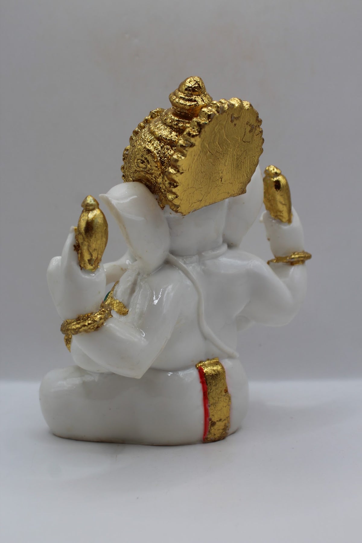 White and gold resin Ganesh murti seated, back view