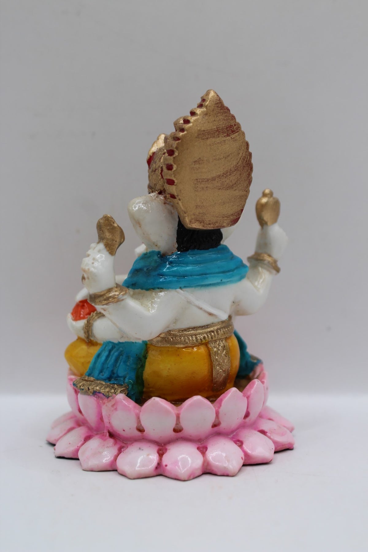 Resin Ganesh murti on pink lotus, yellow dhoti, back view