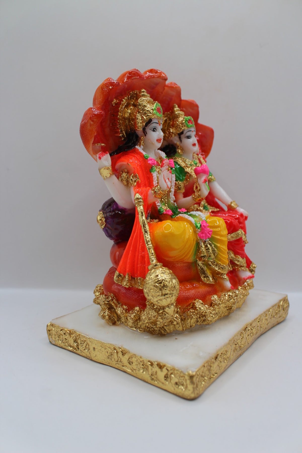 Red resin Vishnu Laxmi murti, seated under Sheshnaag, left side view