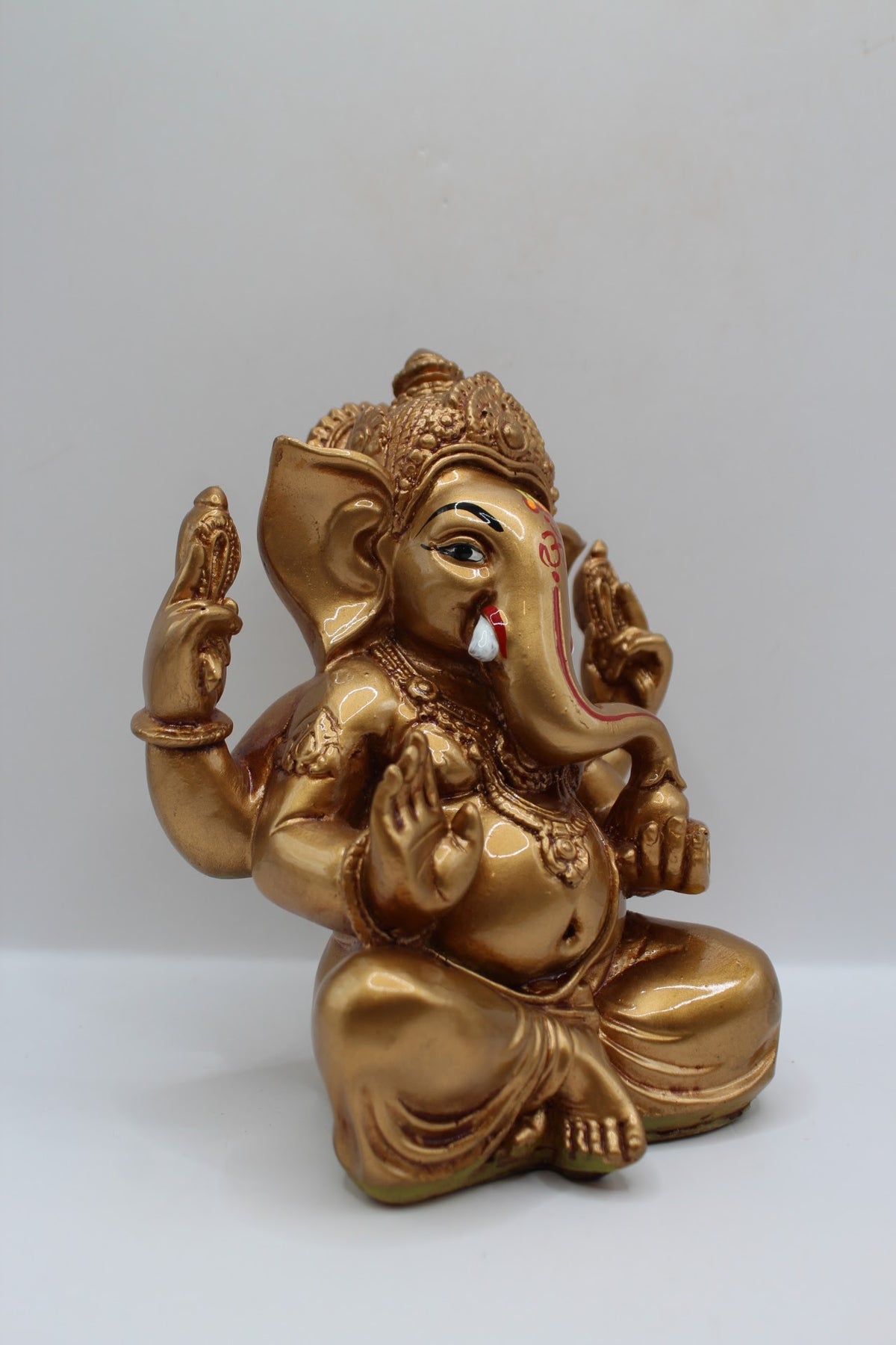 Copper gold resin Ganesh murti seated, left side view