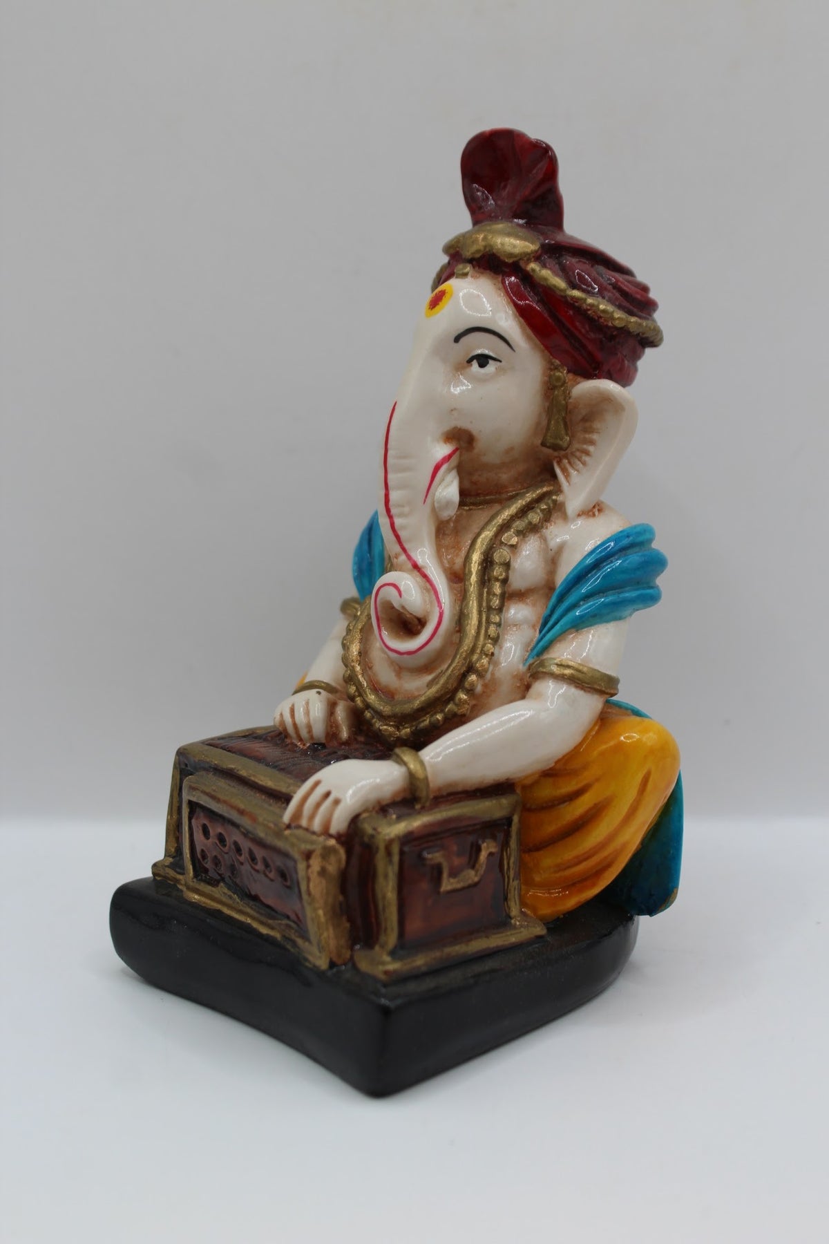 Resin Ganesh murti playing harmonium, red turban, right side view