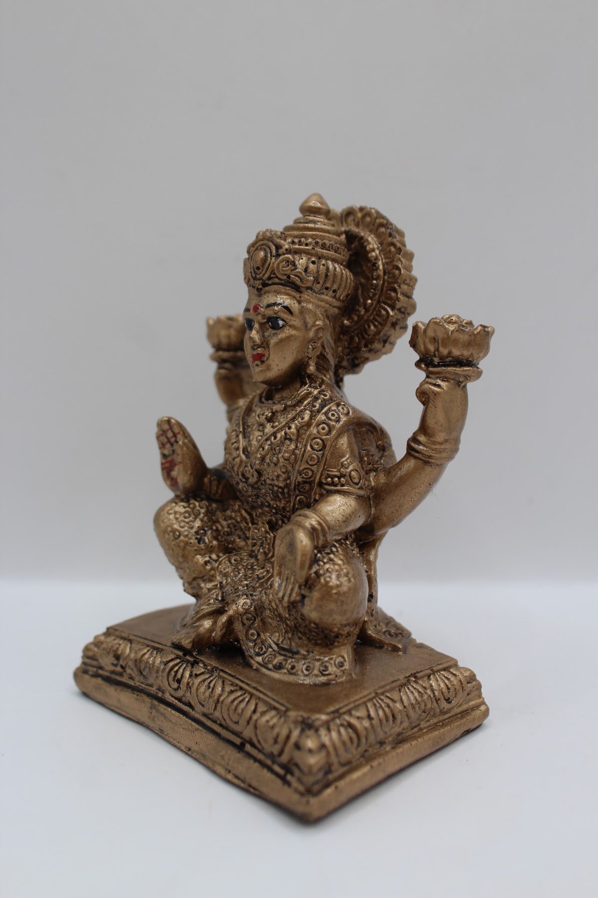 Antique gold resin Laxmi murti seated on square base, right side view