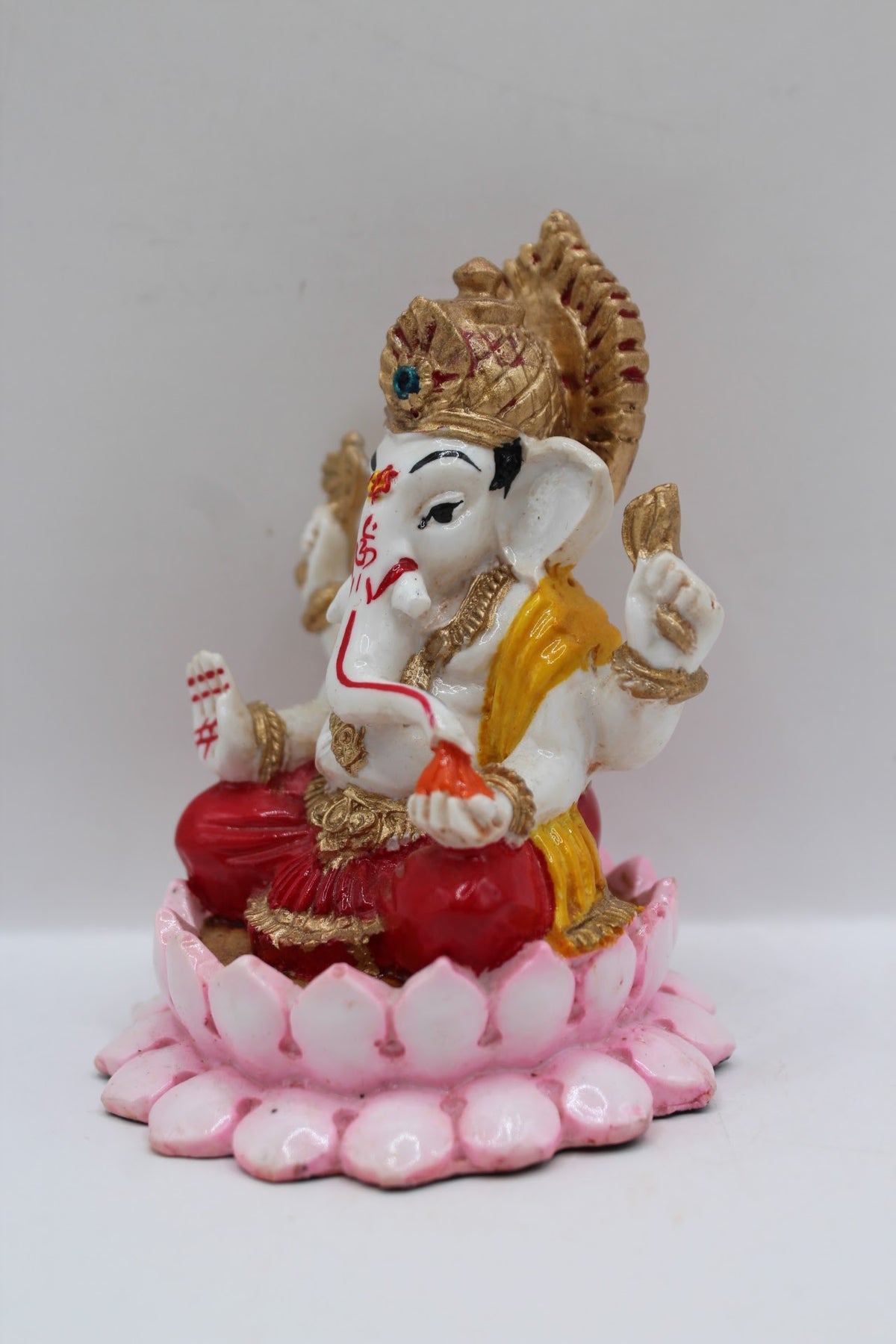 Resin Ganesh murti on pink lotus, red dhoti, right side view