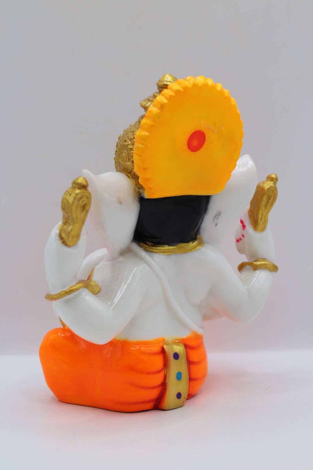 White resin Ganesh murti, orange dhoti, back view