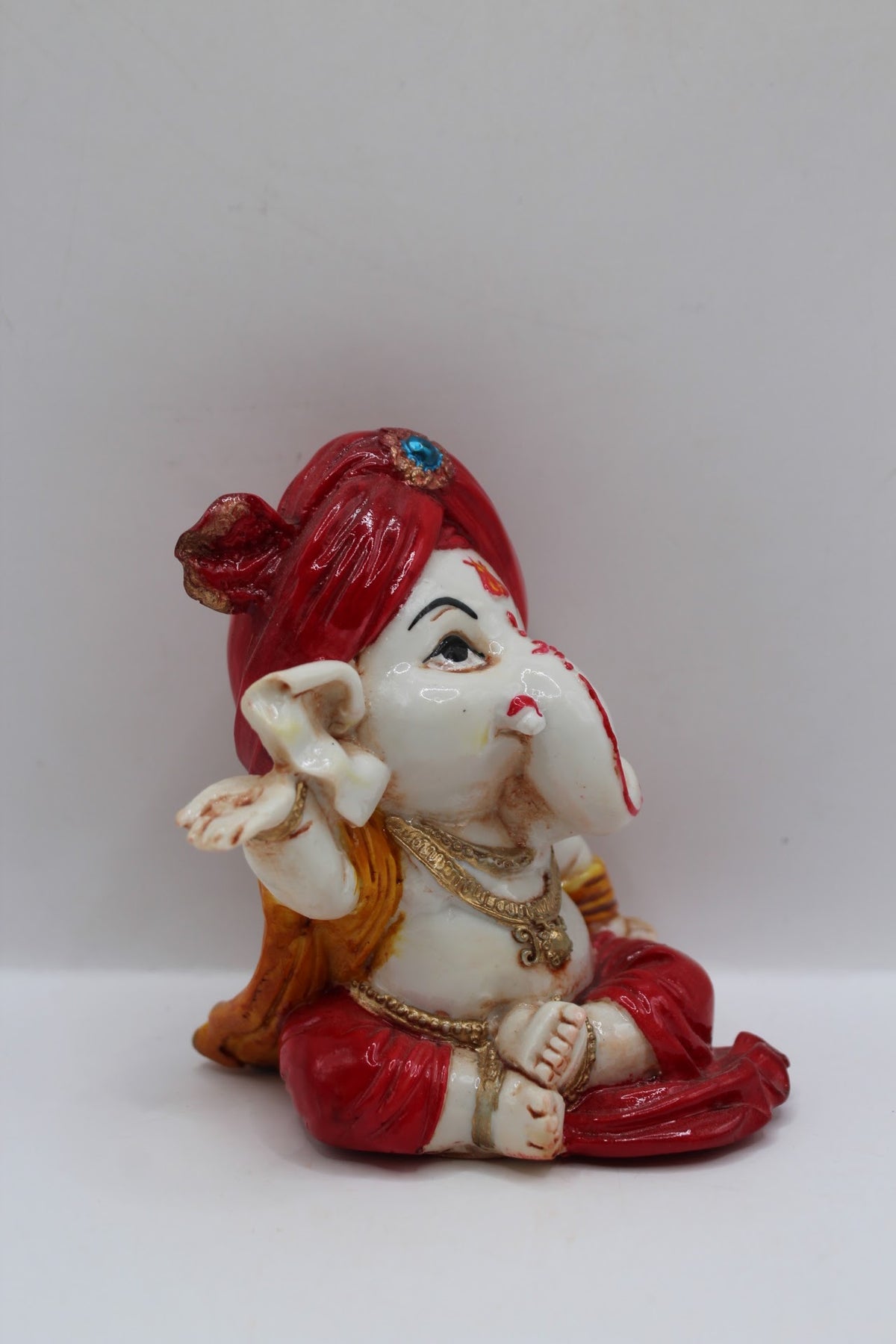 Baby Ganesh murti, red turban and red dhoti, left side view