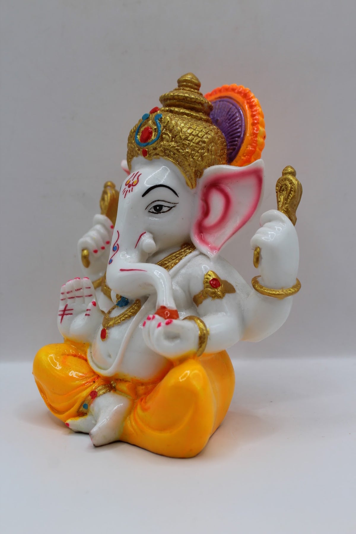 White resin Ganesh murti, yellow dhoti, right side view