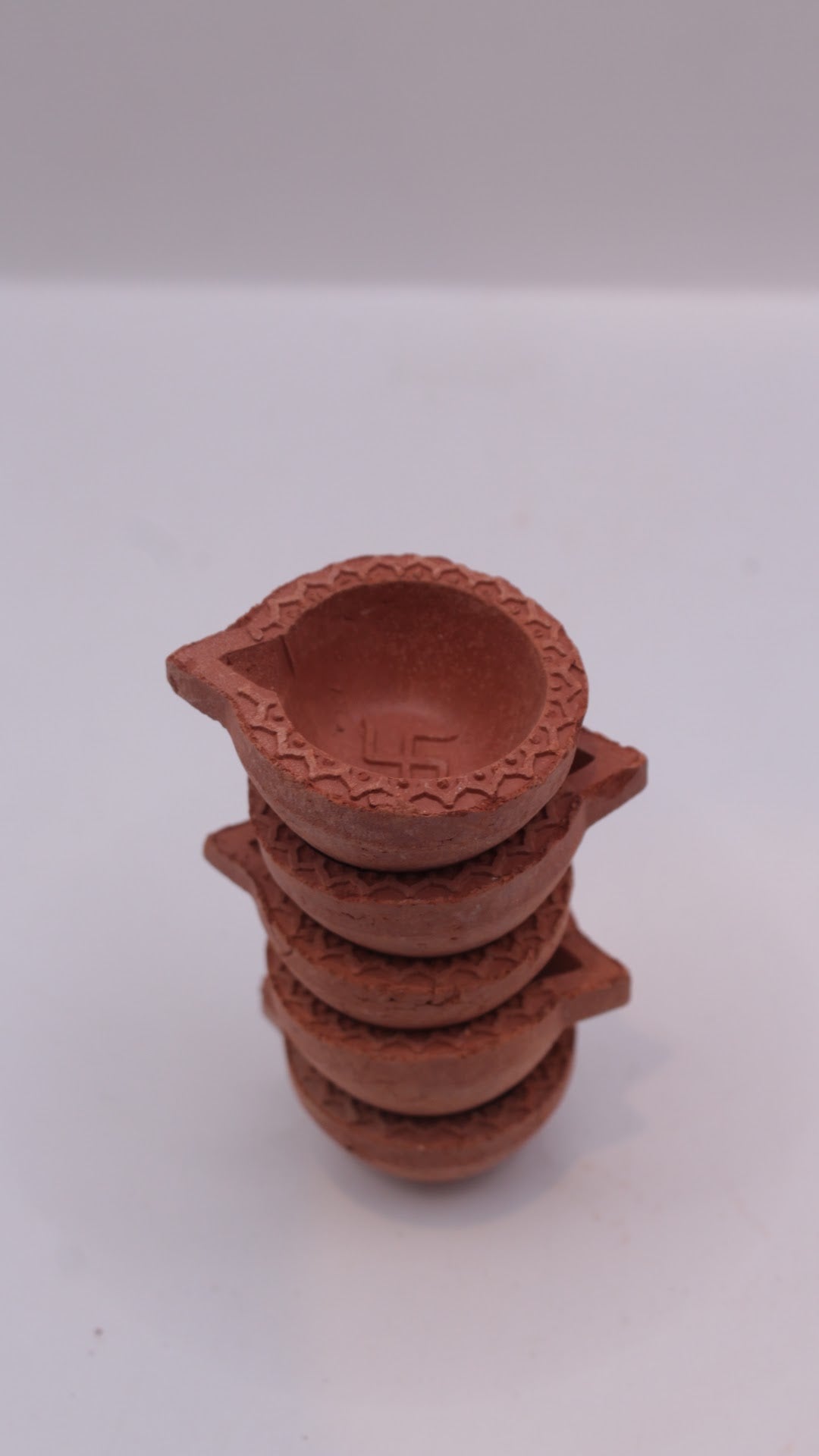 Plain clay diyas stacked, close-up