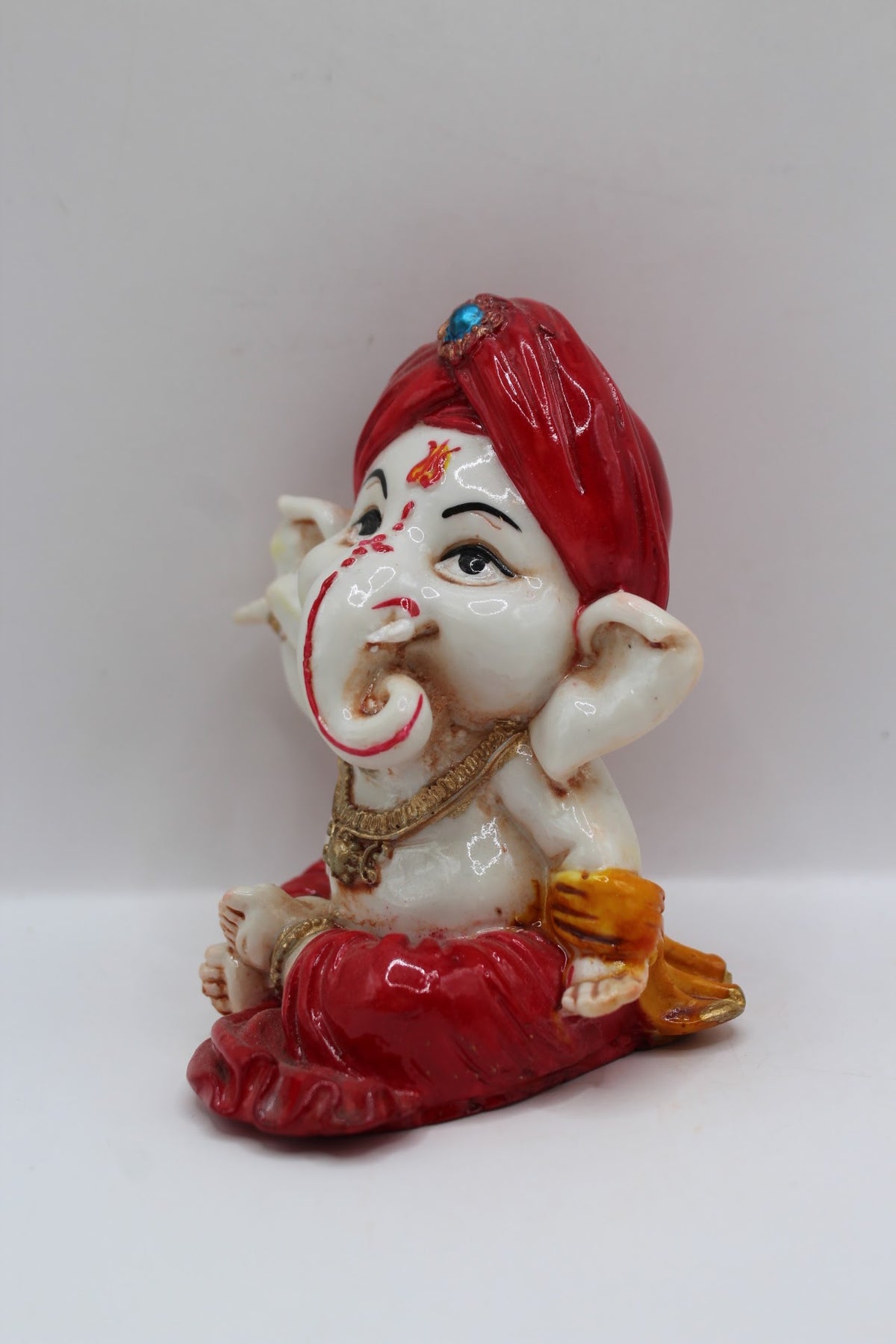 Baby Ganesh murti, red turban and red dhoti, right side view