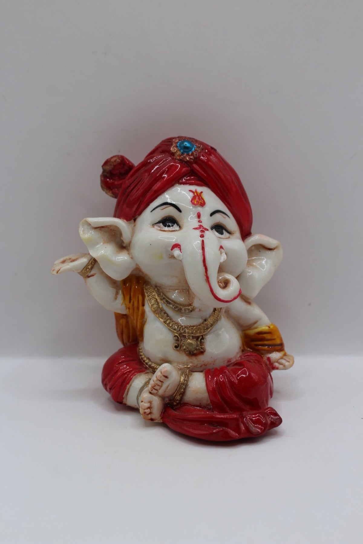 Baby Ganesh murti, red turban and red dhoti, front view