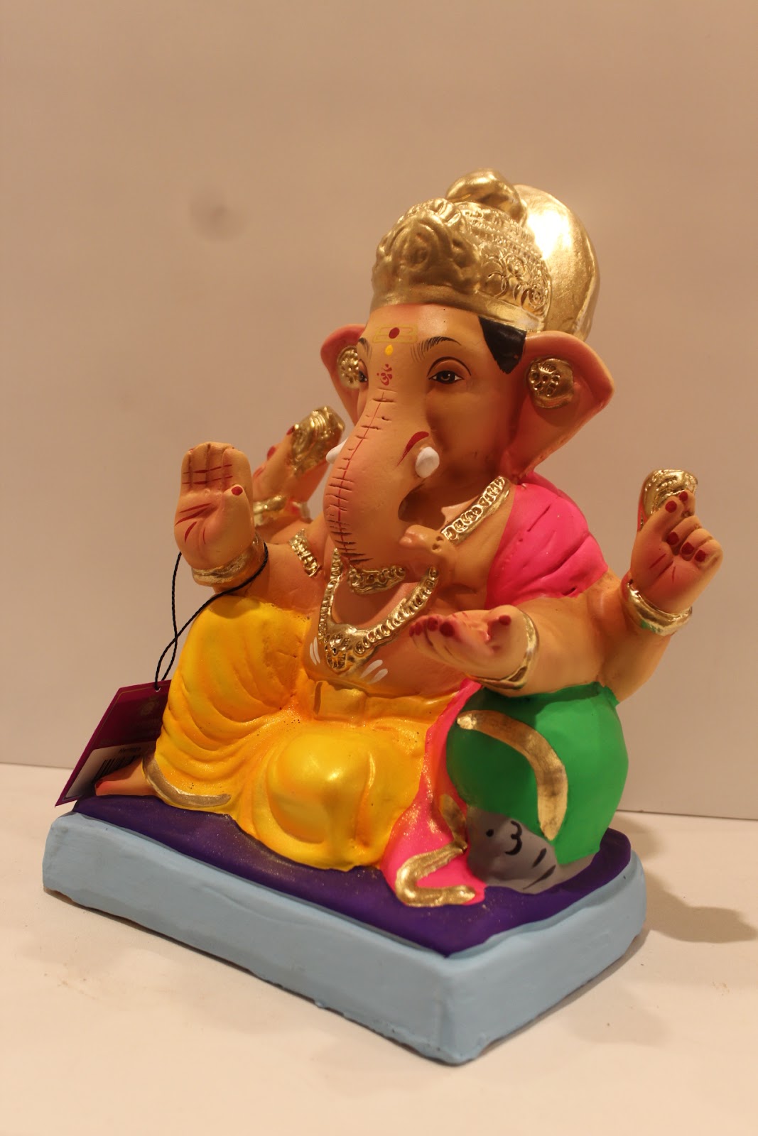 Eco-friendly clay Ganesh idol with pink khes and yellow dhoti, side view
