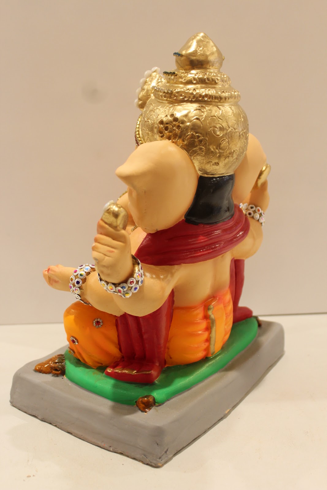 Eco-friendly clay Ganesh idol in jewellery style with pearl and teal crown, back view