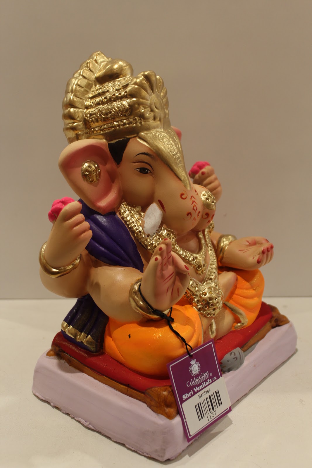 Eco-friendly clay Ganesh idol with purple shawl and orange dhoti, side view