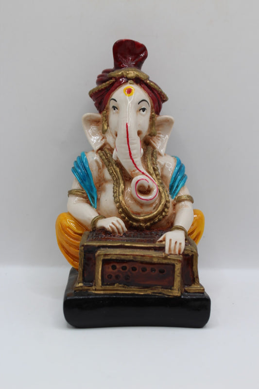 Resin Ganesh murti playing harmonium, red turban, front view