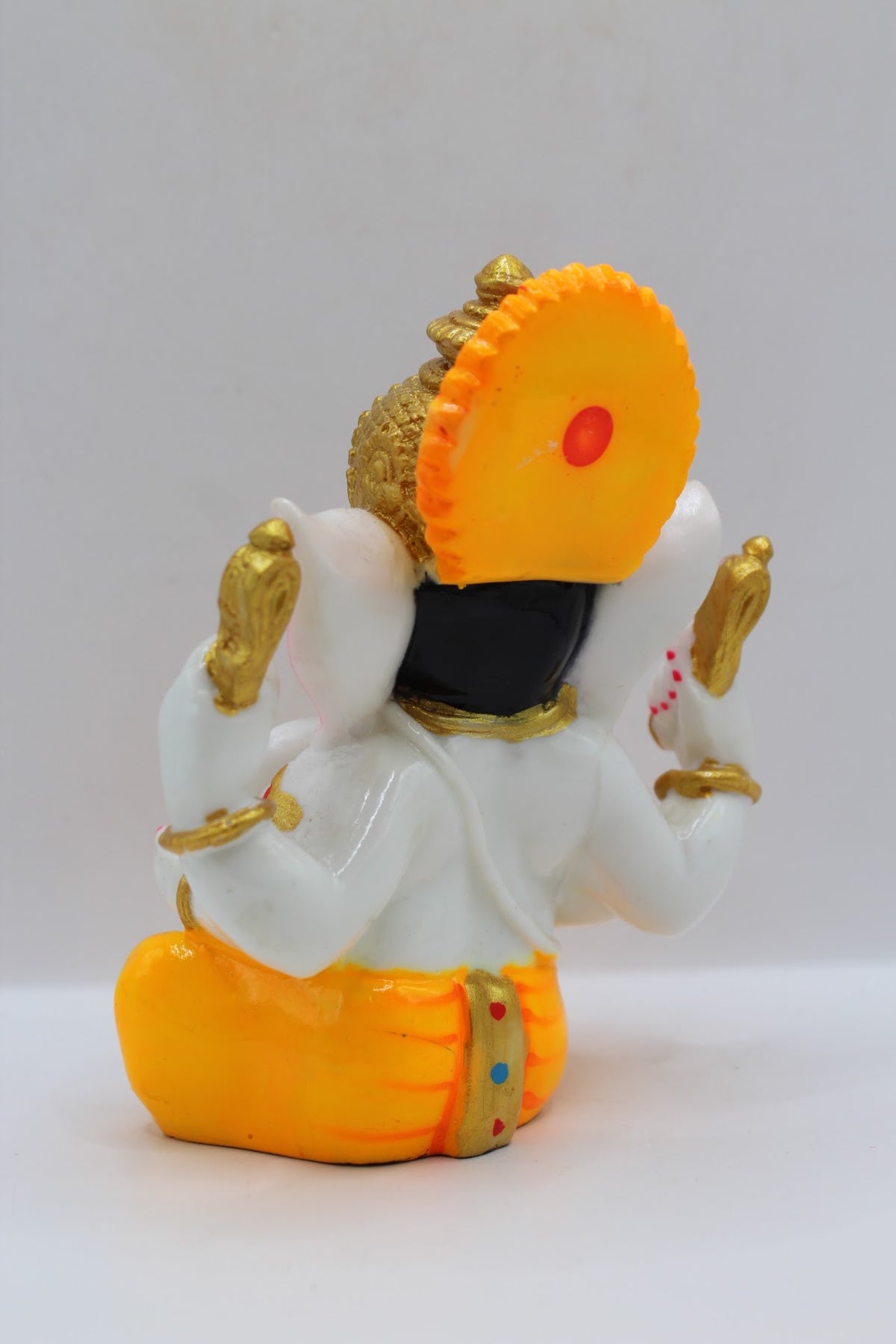 White resin Ganesh murti, yellow dhoti, back view
