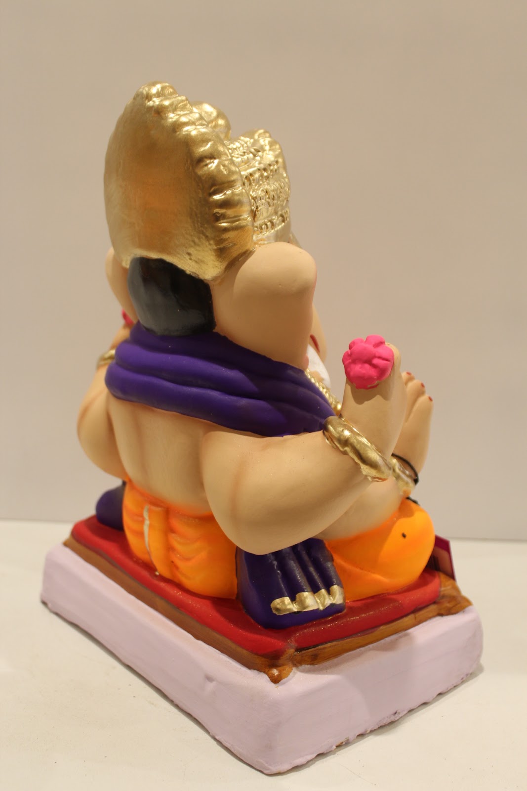 Eco-friendly clay Ganesh idol with purple shawl and orange dhoti, back view
