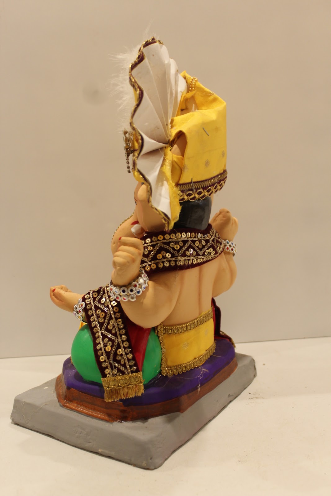 Eco-friendly clay Ganesh idol with yellow pheta and maroon embroidered robe, back view