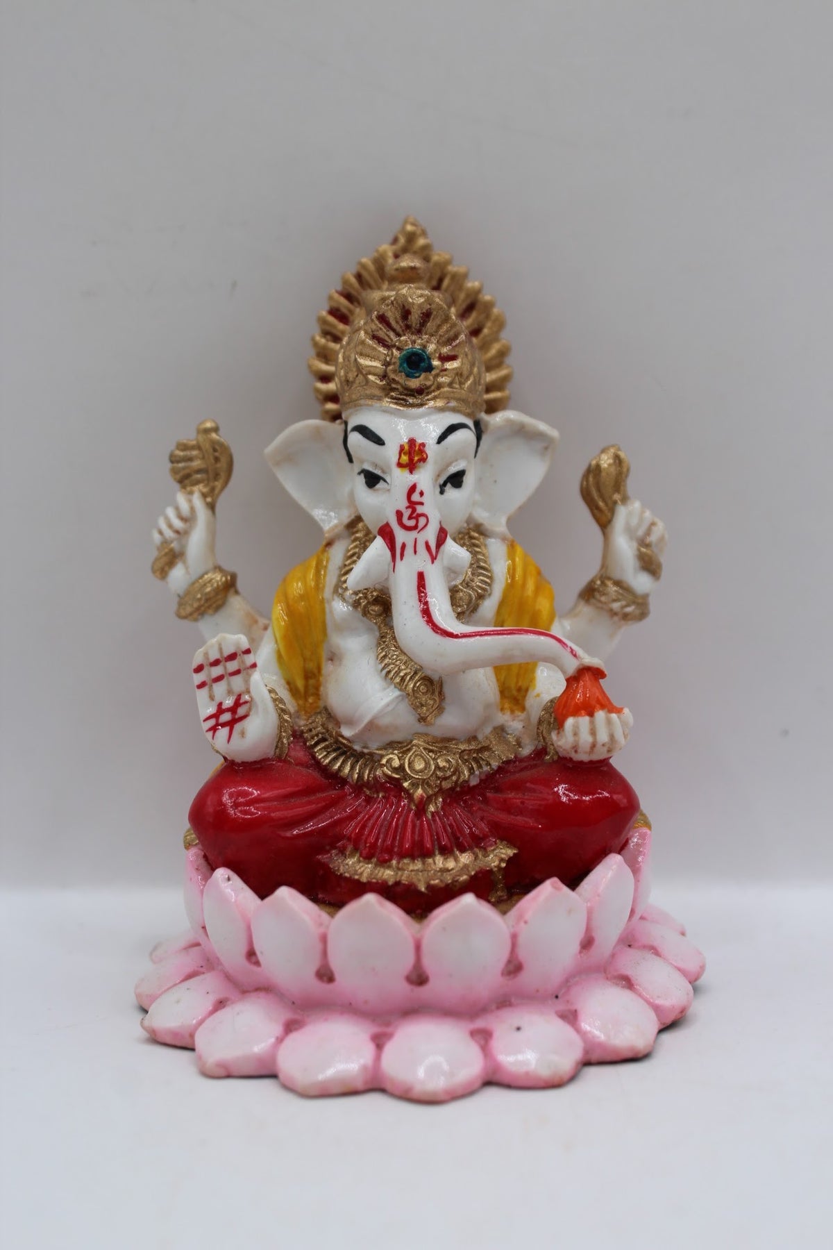 Resin Ganesh murti on pink lotus, red dhoti, front view