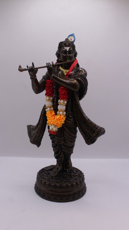 Dark finish resin Krishna statue playing flute, with garland, front view