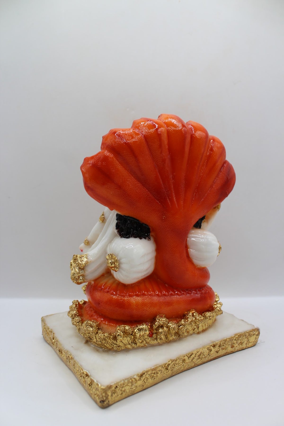 White and orange resin Vishnu Laxmi murti, seated under Sheshnaag, back view