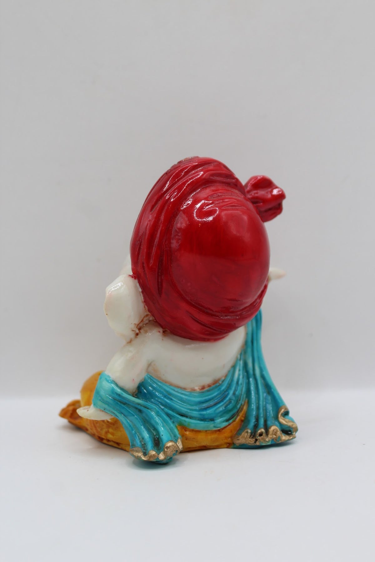 Baby Ganesh murti, red turban and blue scarf, back view