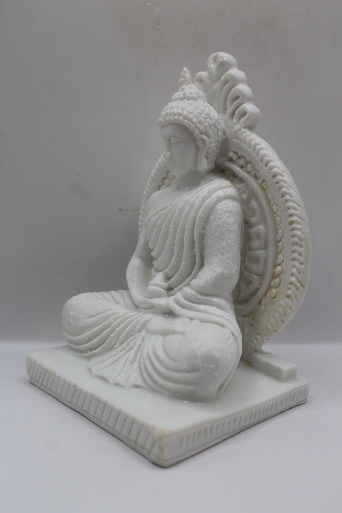 White resin Buddha statue meditating with halo, right side view