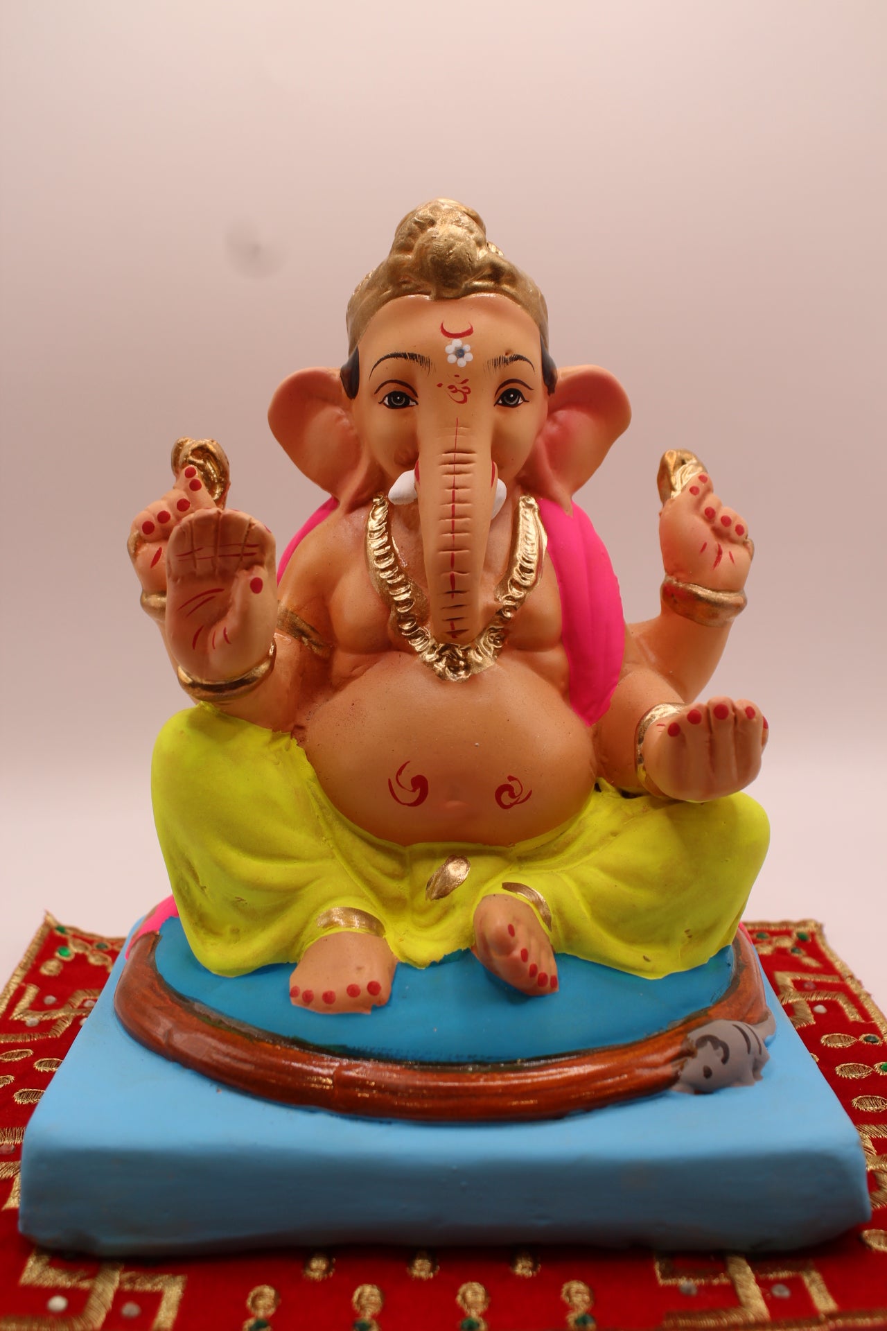 Eco-friendly 8 inch Ganesh Visarjan idol in pink shawl and lime dhoti with gold topknot – front view
