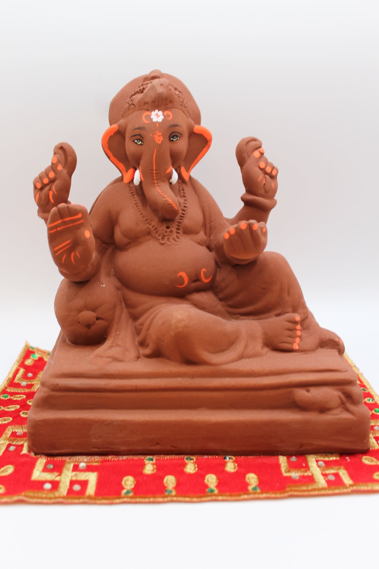 Natural terracotta eco-friendly 8 inch Ganesh Visarjan idol in relaxed pose on stepped base – front view