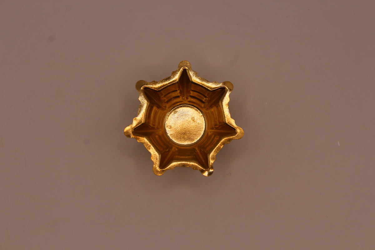 Small gold metal diya, star edge from above