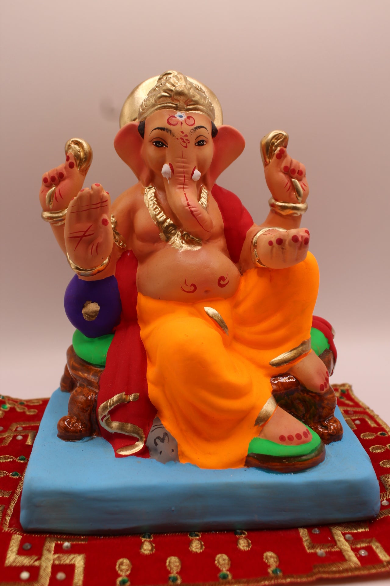 Eco-friendly 8 inch Ganesh Visarjan idol in maroon shawl and orange dhoti on royal seat – front view