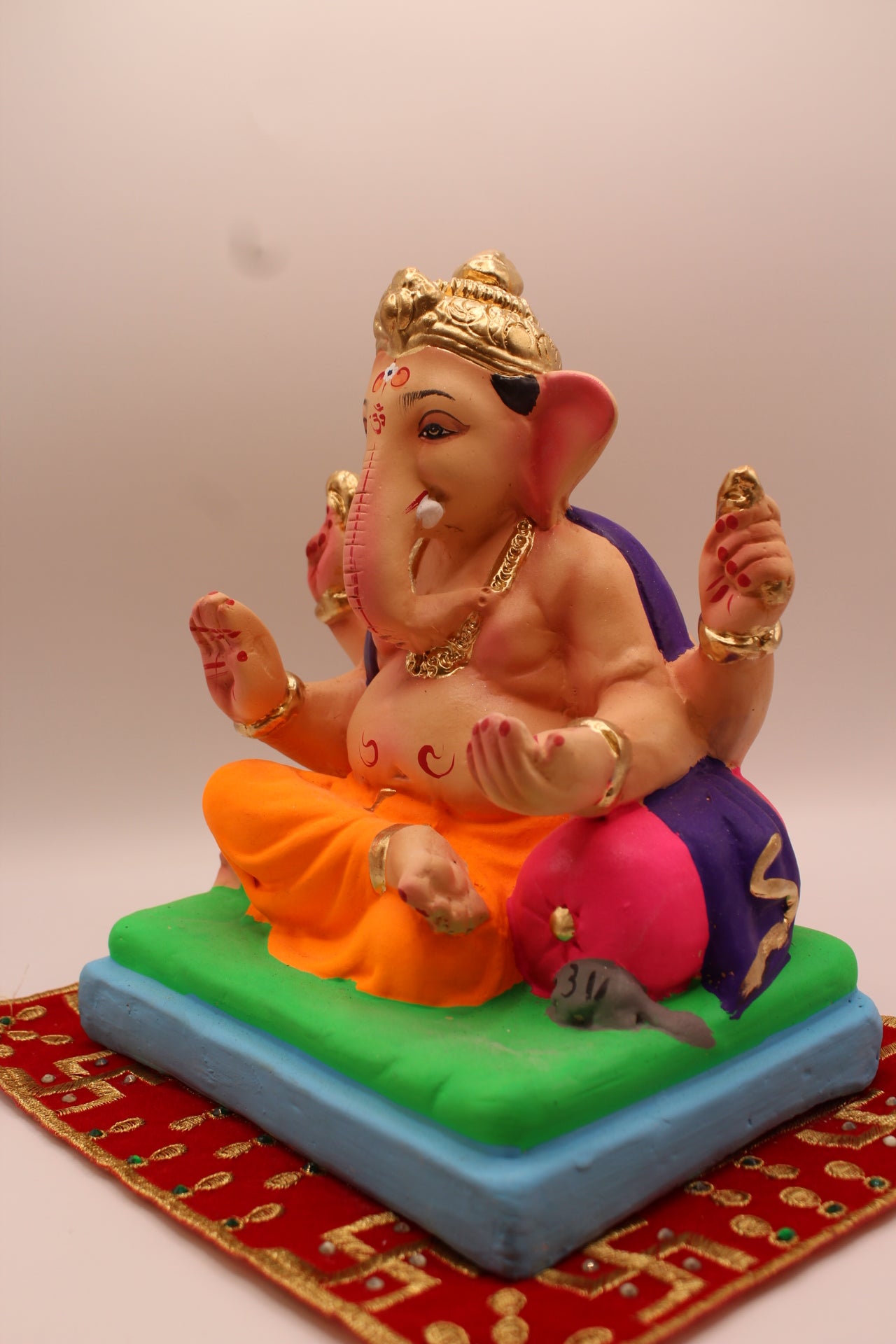 Eco-friendly 8 inch Ganesh Visarjan idol in purple shawl and orange dhoti – detail view