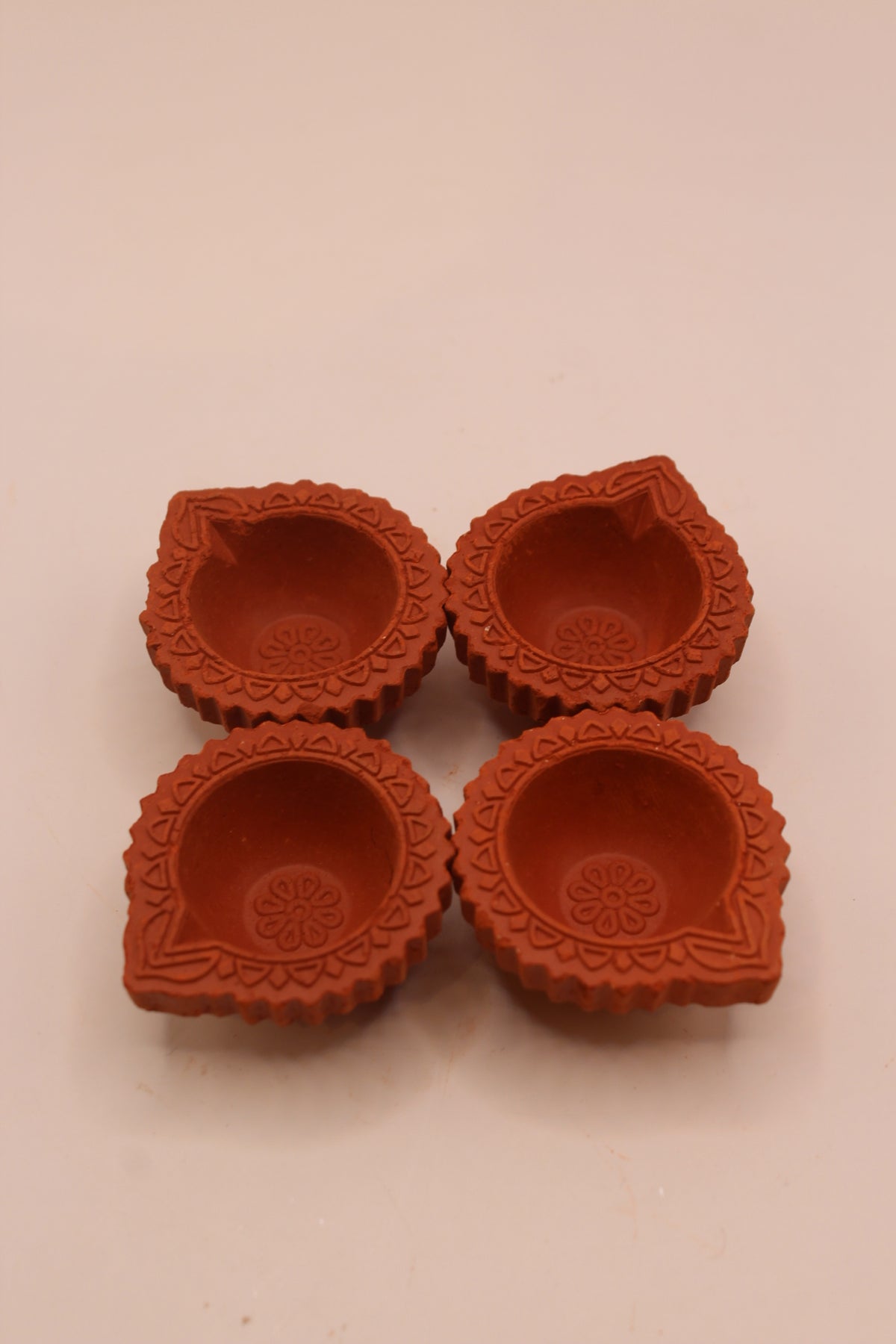 Four clay diyas with fluted edges