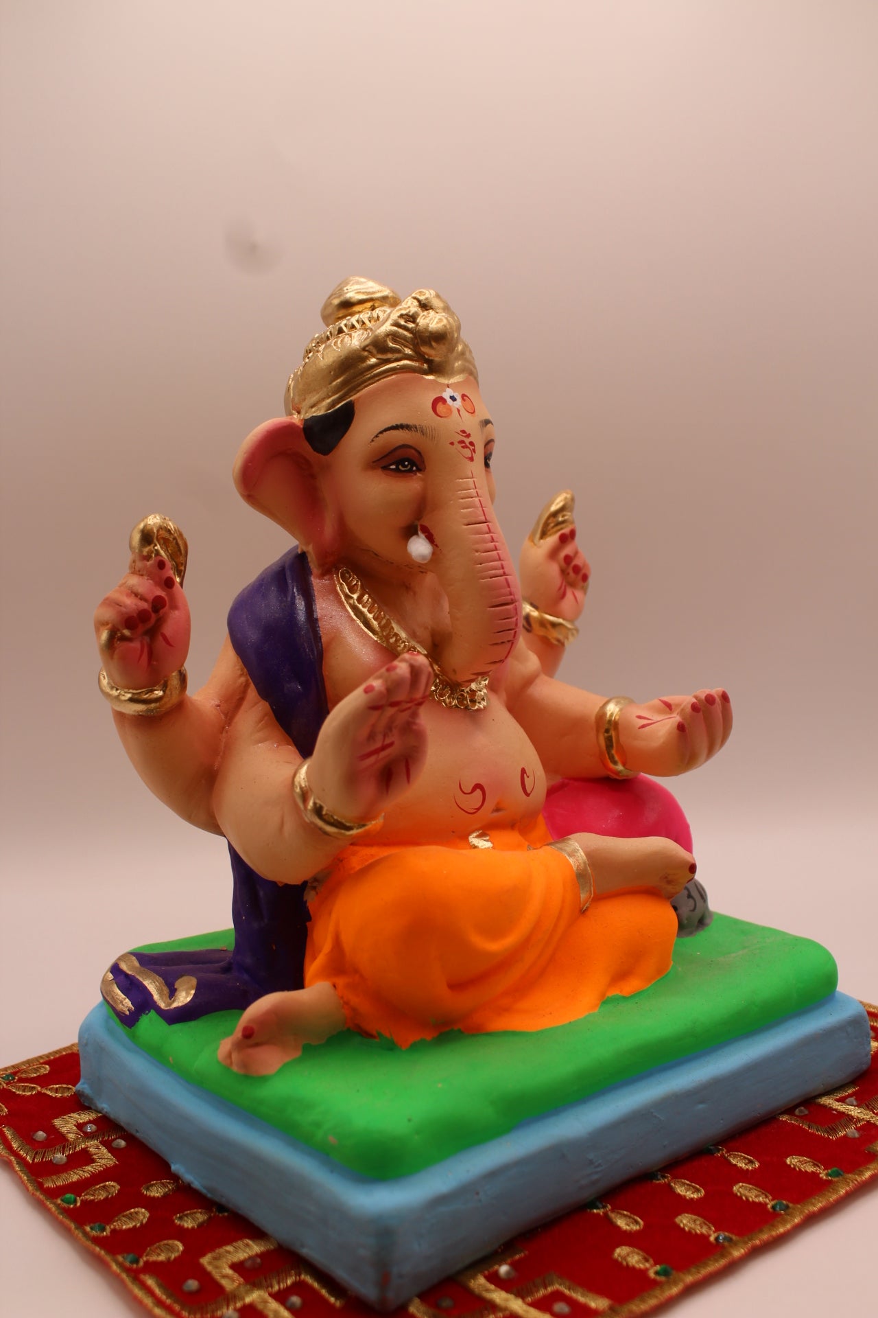 Eco-friendly 8 inch Ganesh Visarjan idol in purple shawl and orange dhoti – side view