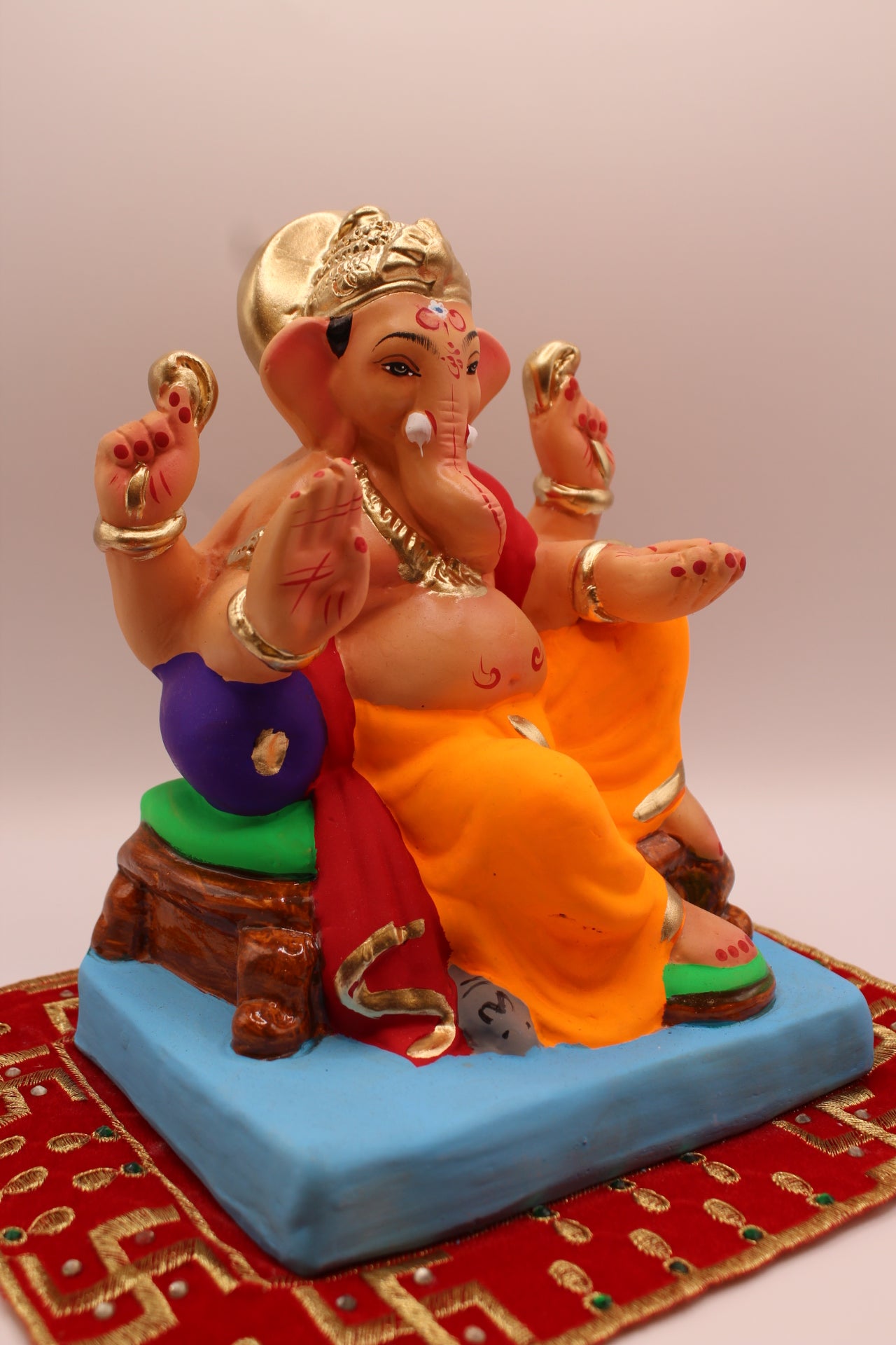 Eco-friendly 8 inch Ganesh Visarjan idol in maroon shawl and orange dhoti – side view
