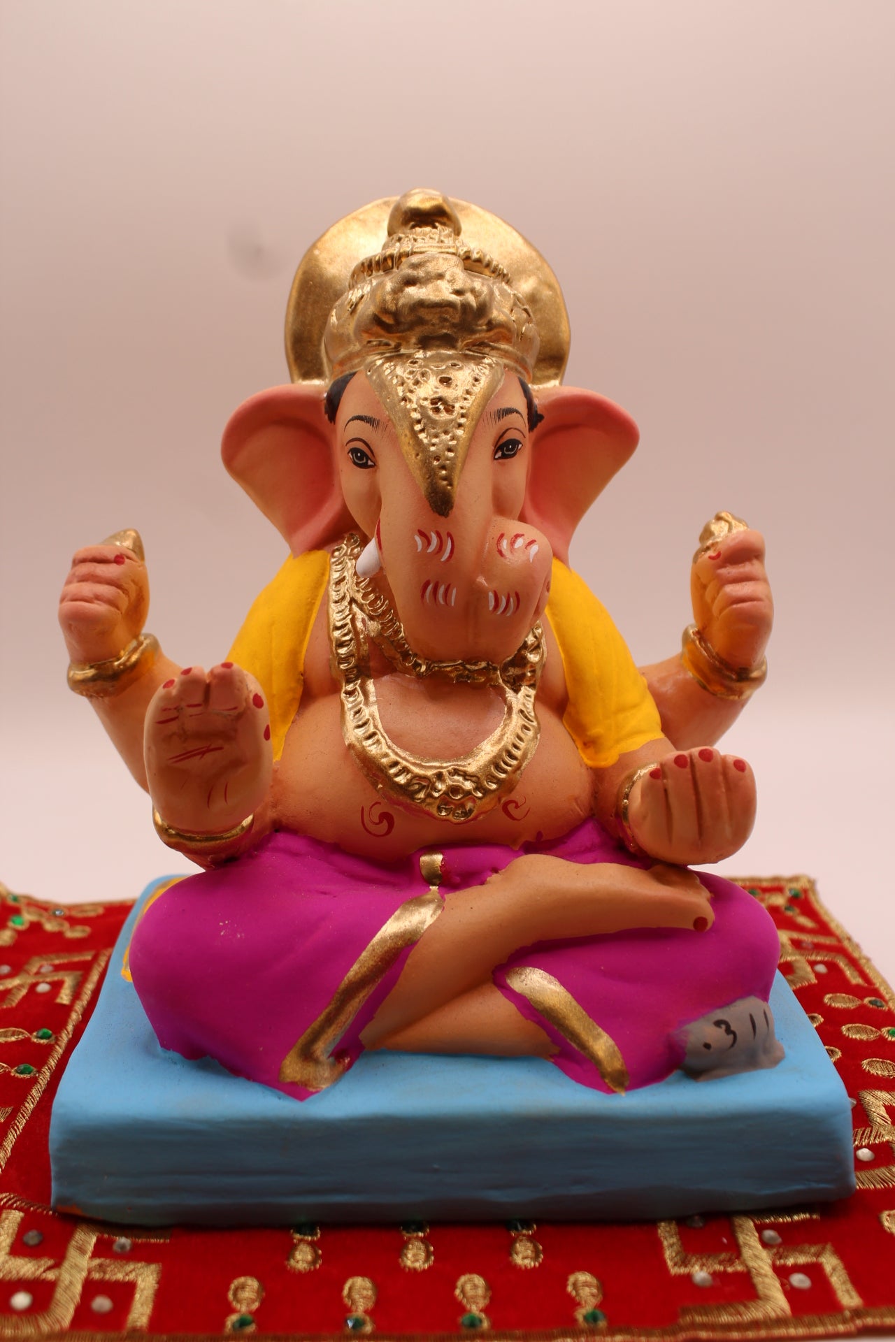 Eco-friendly 8 inch Ganesh Visarjan idol in yellow shawl and magenta dhoti with halo crown – front view